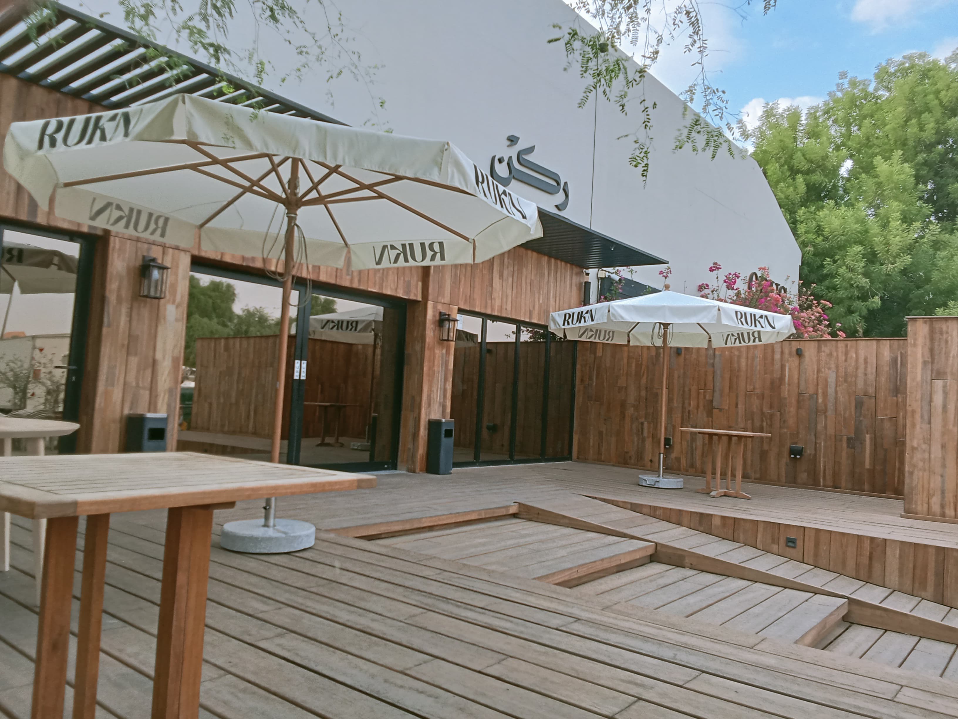 Piazza umbrella with custom logo installed over outdoor seating area in Al Ain